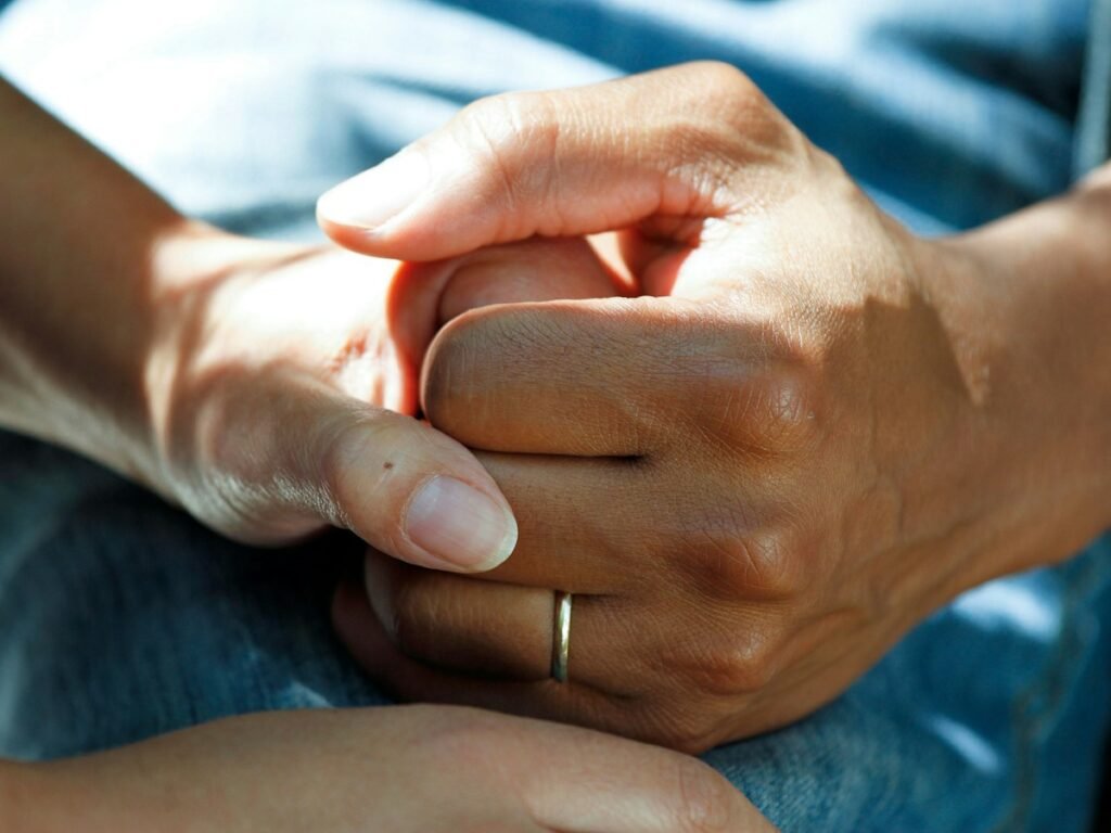 A carer holds an older person's hand
