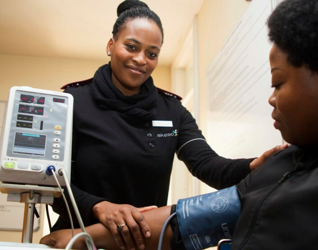 A nurse checks an older woman's blood pressure during a home visit
