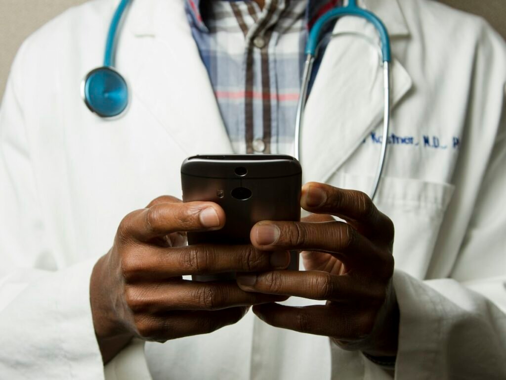 A clinician holds a phone, ready to send a family update